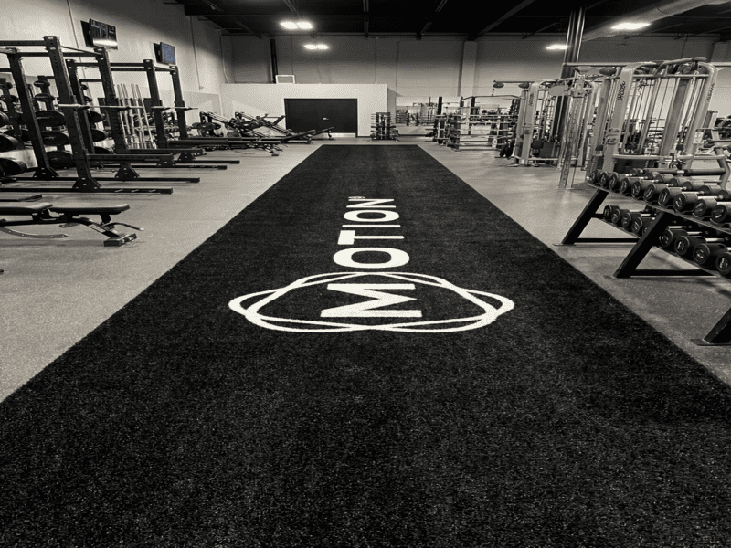 Worker brushing gym turf to keep fibers upright